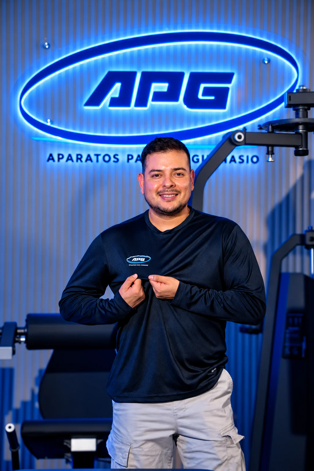 Asesor de APG frente al logo iluminado del showroom